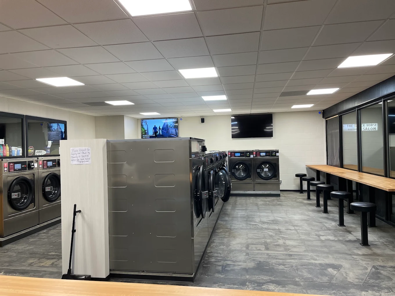 Clean Life Laundry interior with washers, TVs, and counter seating